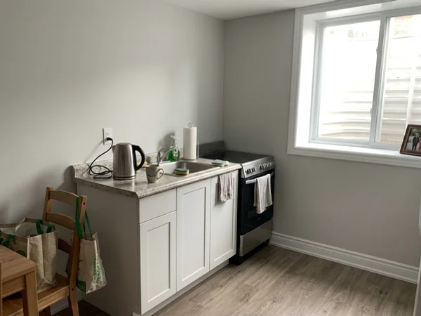 Finished rebuilt basement rental unit with painted walls, baseboards and kitchenette